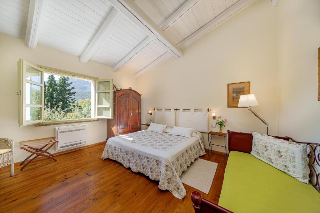 a bedroom with a bed and a couch at Wine Resort Ledà d'Ittiri in Fertilia