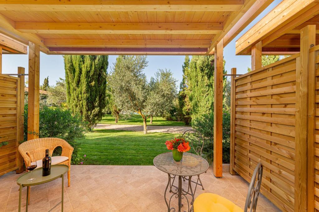 a patio with a table with flowers on it at Wine Resort Ledà d'Ittiri in Fertilia