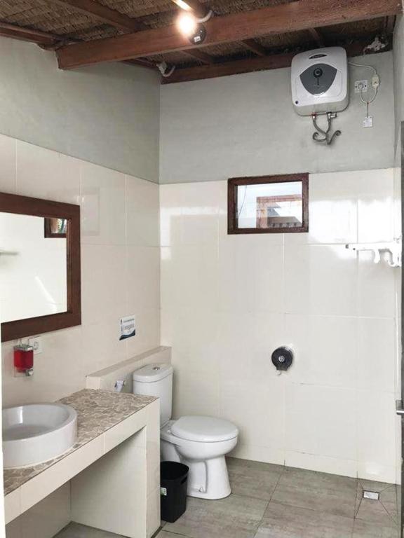 un bagno bianco con un water e un lavandino di Gili One Resort a Gili Trawangan