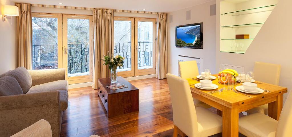 a living room with a table and a dining room at Tavistock Place Apartments in London