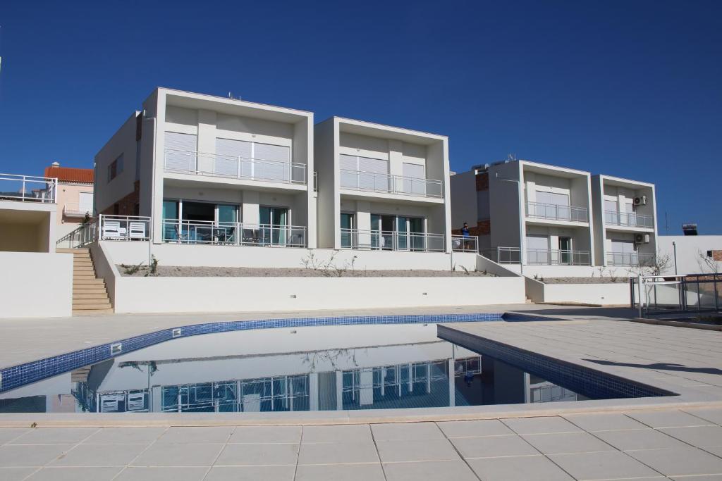 a building with a swimming pool in front of a building at Bela Baia Holiday in Salir de Porto