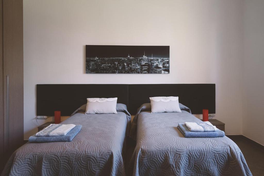 クレアッツォにあるB&B Gli Olmiのベッド2台が隣同士に設置された部屋です。