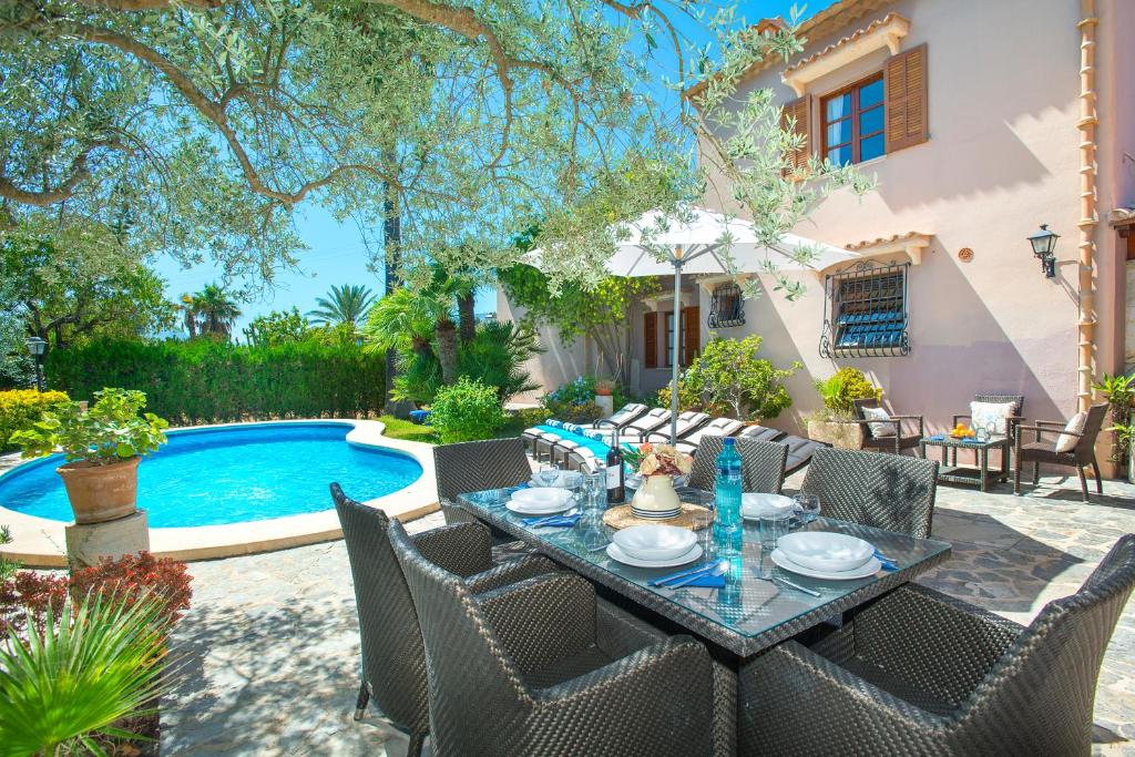 ポリェンサにあるOwl Booking Villa Suavet Petit - Exclusive Property with a Stunning Poolのプールサイドのパティオ(テーブル、椅子付)