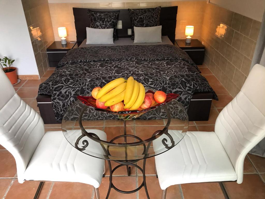 een dienblad bananen en appels op een tafel voor een bed bij Suite luxe vue sur piscine et parc in Miramas