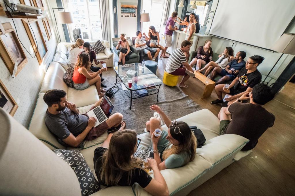 eine Gruppe von Menschen, die auf einer Couch sitzen in der Unterkunft Goodmorning Solo Traveller Hostel in Lissabon