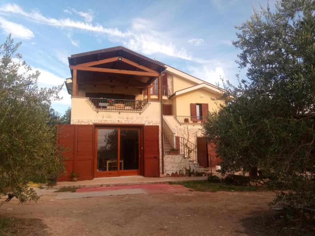 une maison avec une porte rouge devant elle dans l'établissement Residence degli ulivi, à Ossi