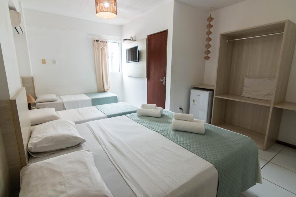 ein Hotelzimmer mit 3 Betten in einem Zimmer in der Unterkunft Hotel Gogó da Ema in Maceió