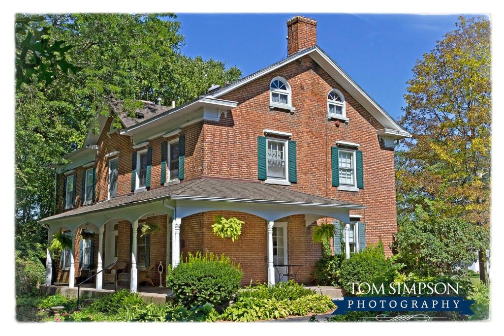 a red brick house with white windows at Willard Richards Inn in Nauvoo