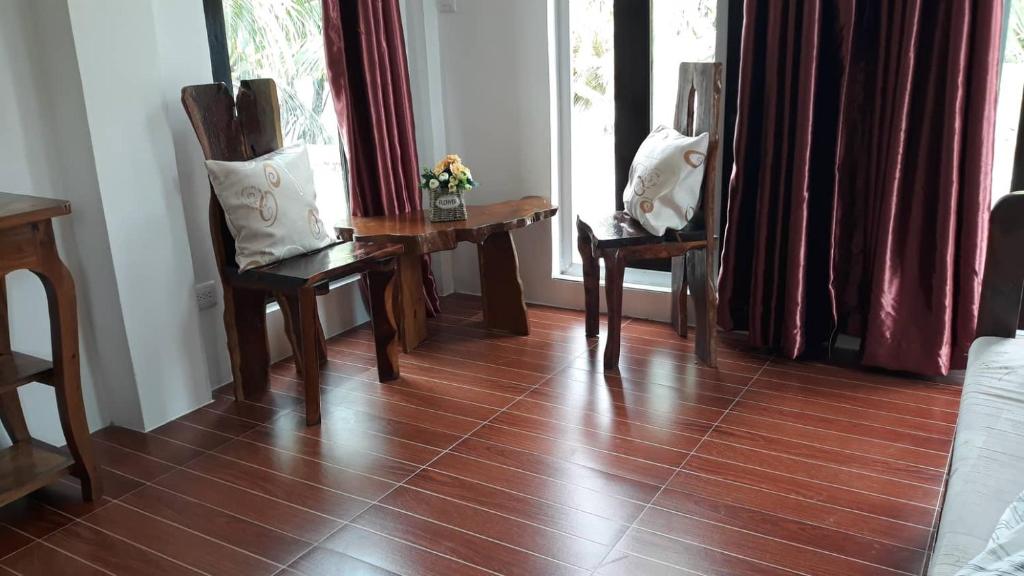 a room with a wooden floor with chairs and a window at Marnin's Place in Boracay