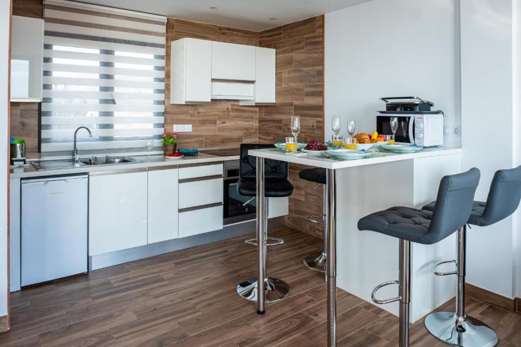 a kitchen with white cabinets and a island with bar stools at Loft del Mar 2 Jandia in Playa Jandia