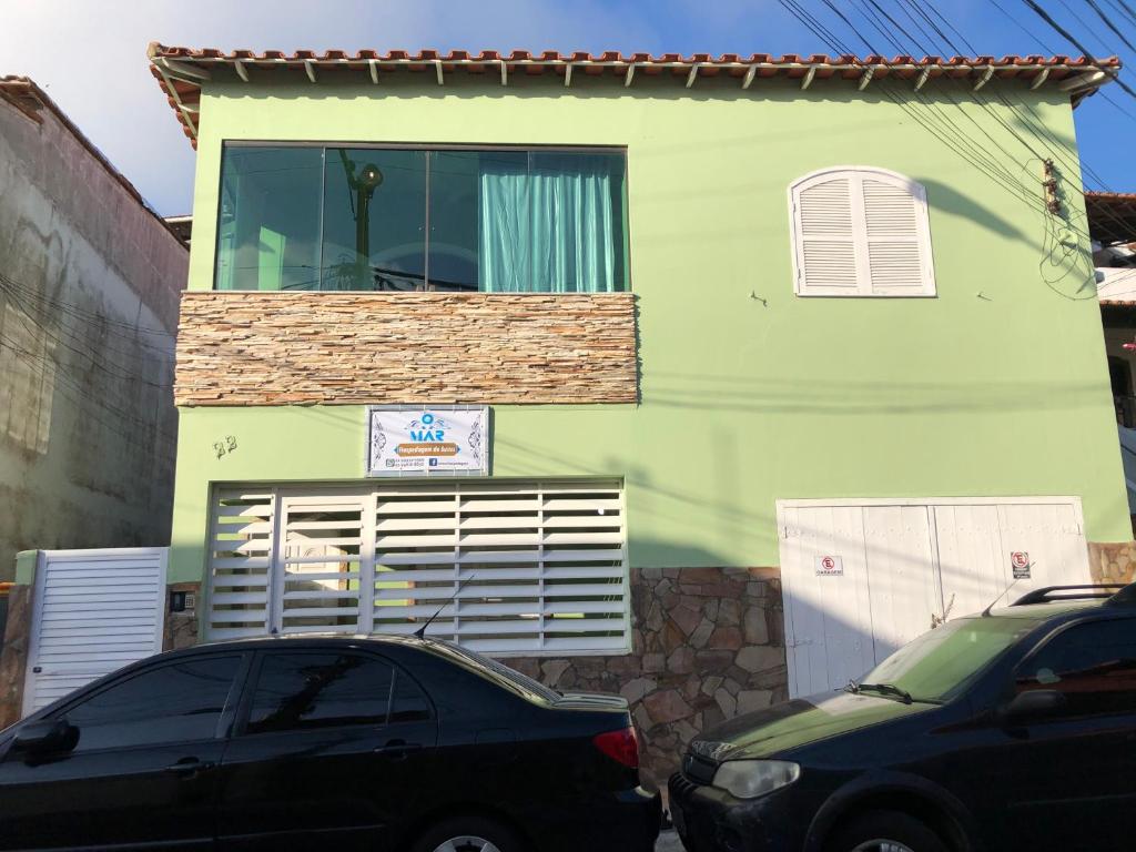 un coche negro estacionado frente a una casa en O Mar Hospedagem - SUÍTES PRIVADAS, en Arraial do Cabo