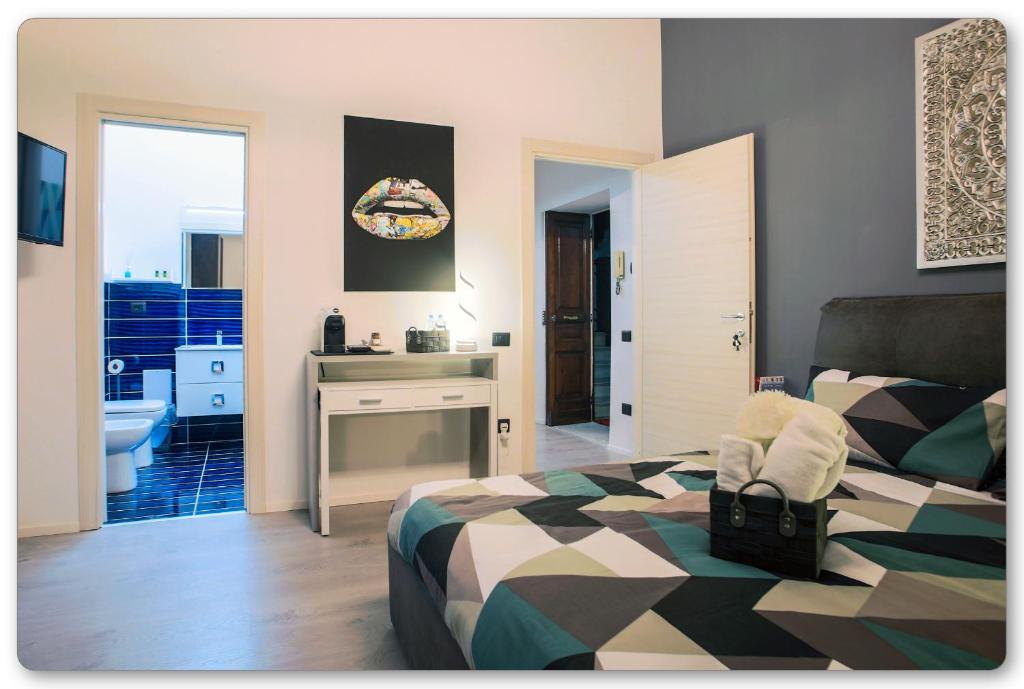 a bedroom with a bed and a bathroom with a sink at B&B Palazzo Di Florio in Cava deʼ Tirreni