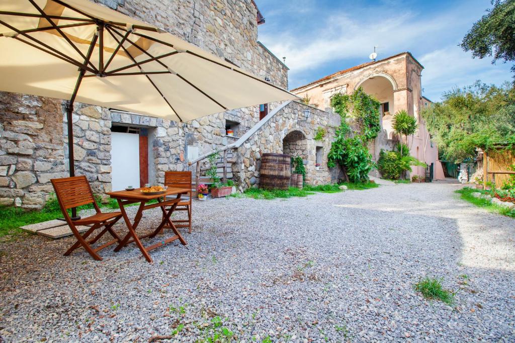 stół i krzesła z parasolem przed budynkiem w obiekcie Gaiano Apt w Sorrento