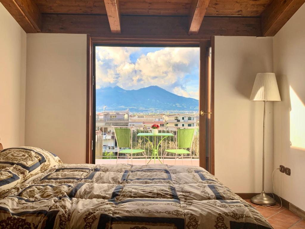a bedroom with a large window with a mountain view at Pompei Campania Felix in Poggiomarino