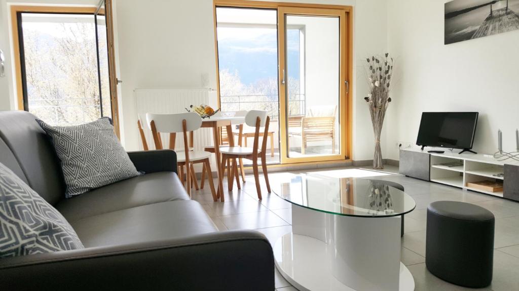 ein Wohnzimmer mit einem Sofa und einem Tisch in der Unterkunft Les Picaillons - A 200m du lac in Aix-les-Bains