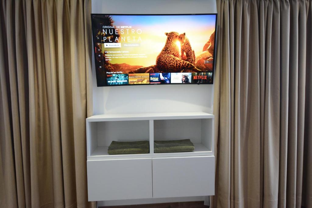 a flat screen tv hanging on a wall behind a curtain at Loft del Mar 2 Jandia in Playa Jandia