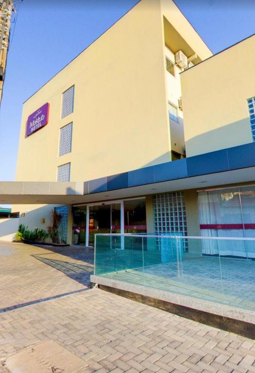 a large building with a swimming pool in front of it at Maktub Hotel in Floriano