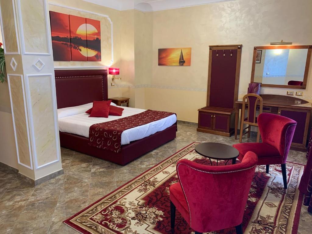 カッシーノにあるHotel Ristorante Al Boschettoのベッド、テーブル、椅子が備わるホテルルームです。