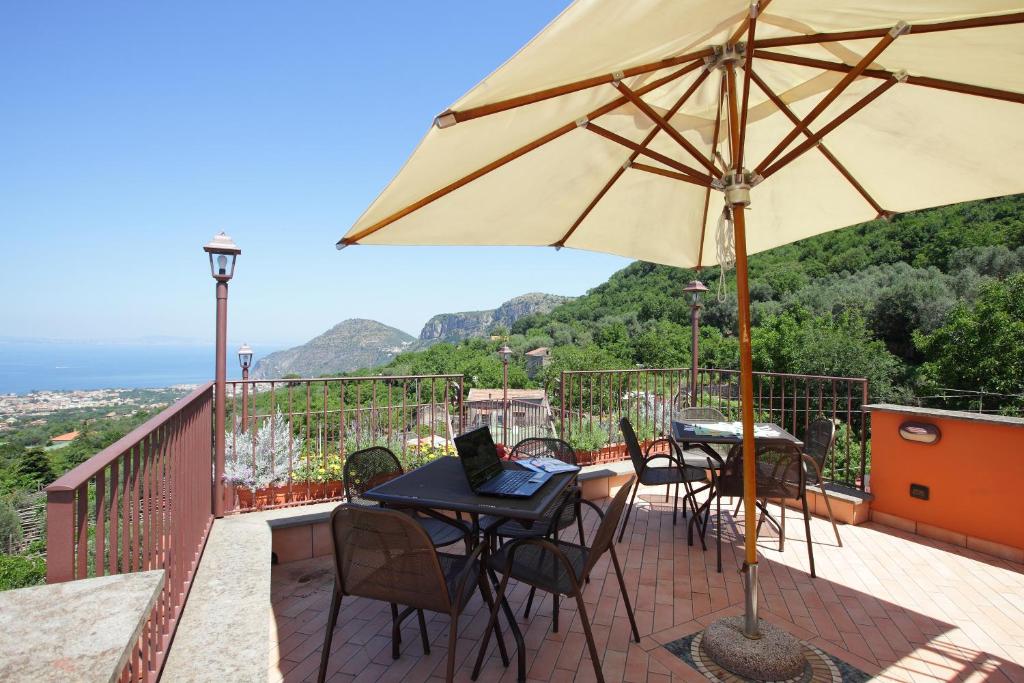 a patio with tables and chairs and an umbrella at Residence l'Incanto in Piano di Sorrento