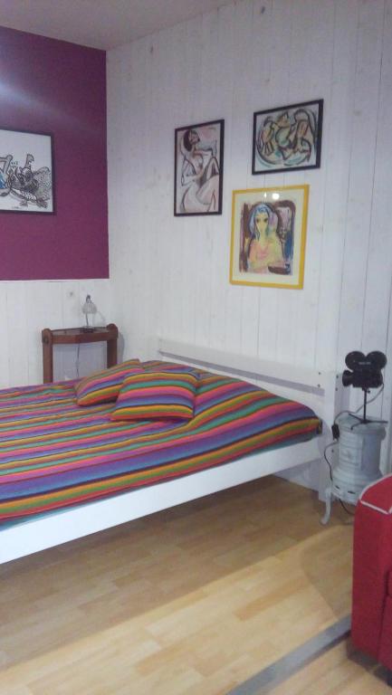 1 dormitorio con 1 cama grande y algunas fotografías en la pared en Studio climatisé Corps Saints en Aviñón