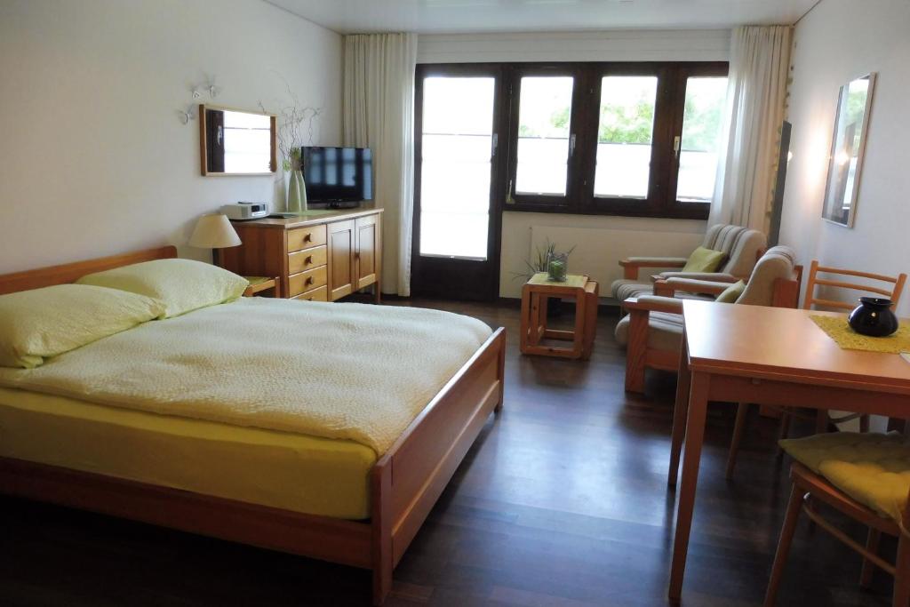 1 dormitorio con 1 cama y sala de estar con mesa en Aragon V149, en Ernen