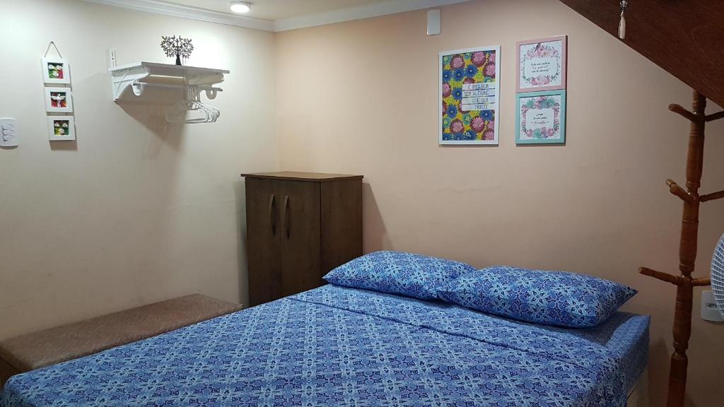 - une chambre avec un lit et une couette bleue dans l'établissement Estilo Residence II, à São Lourenço