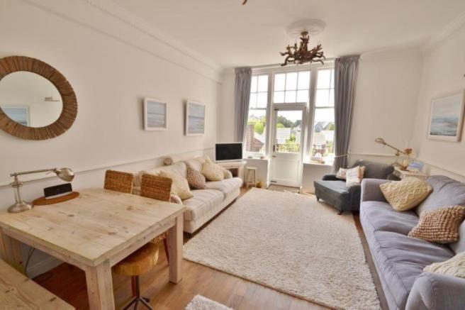 a living room with a couch and a table at Springhill House in Swanage