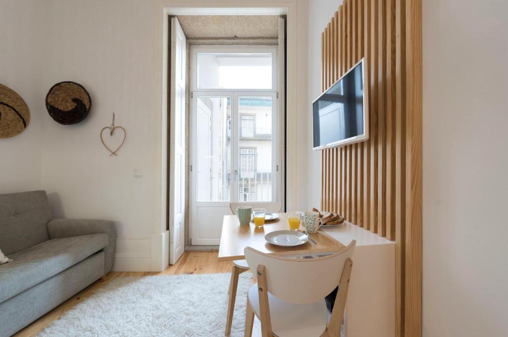 - un salon avec une table et un canapé dans l'établissement LovelyStay - Quiet & Modern Loft minutes away from iron bridge, à Porto