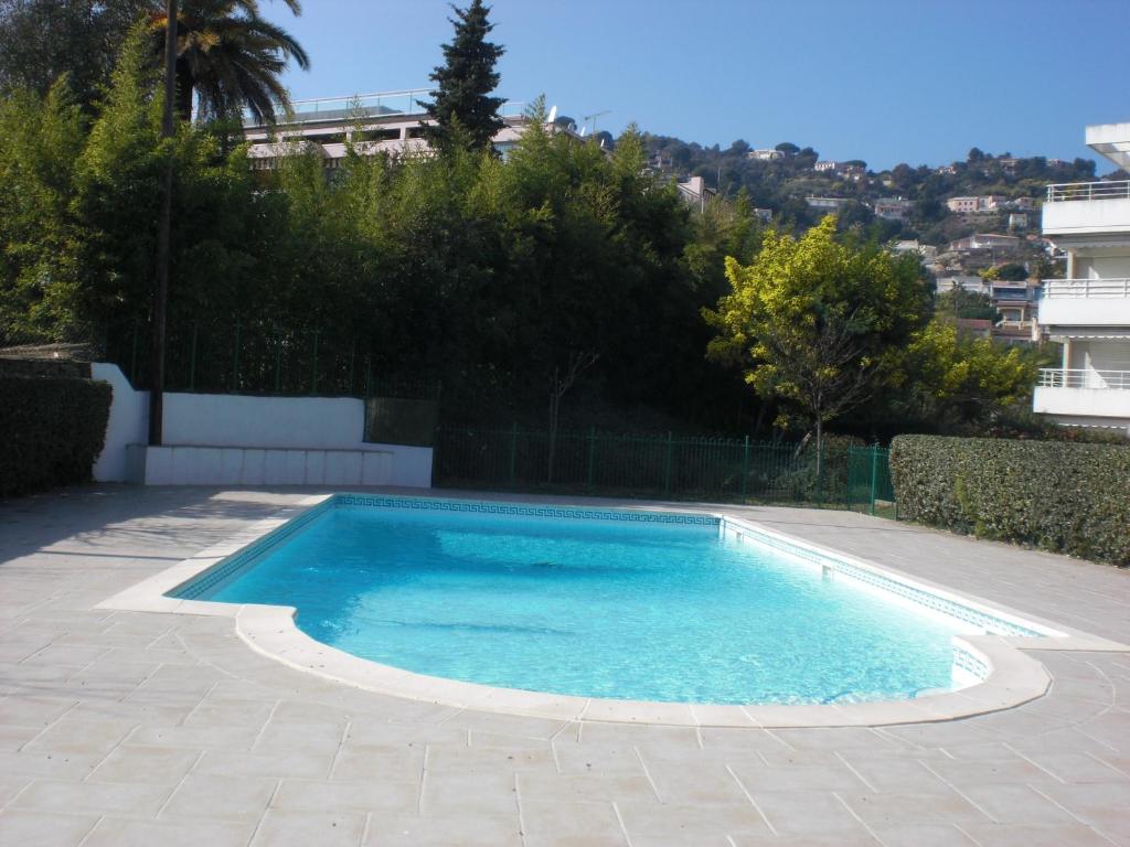 una piscina con acqua blu in un cortile di Résidence avec piscine, plage à 100 m, Cannes et Juan les Pins à 5 min, WiFi a Golfe-Juan