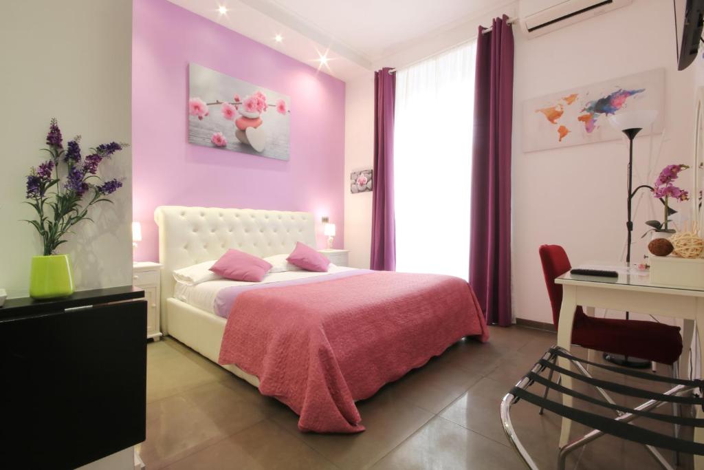 um quarto rosa com uma cama e uma secretária em Vatication B&B em Roma