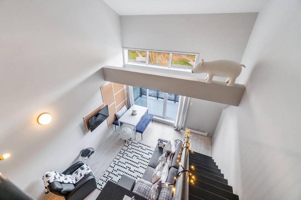 uma vista superior de uma sala de estar com uma escada em INITIAL - L'OURS - Mont-Sainte-Anne em Beaupré