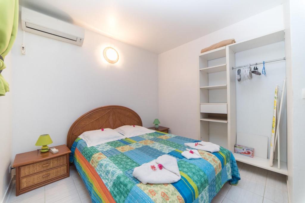 ein Schlafzimmer mit einem Bett mit zwei Handtüchern darauf in der Unterkunft Appartement Majo in Le Lamentin