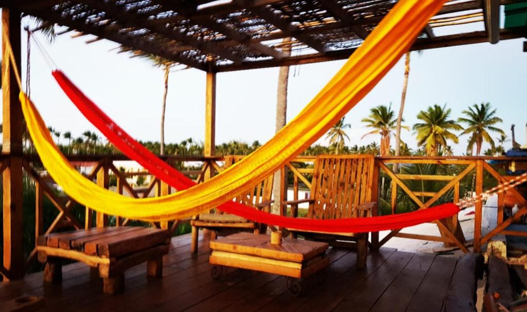 a hammock on a deck with chairs and palm trees at Private Rooms-Art Punta Cana in Punta Cana