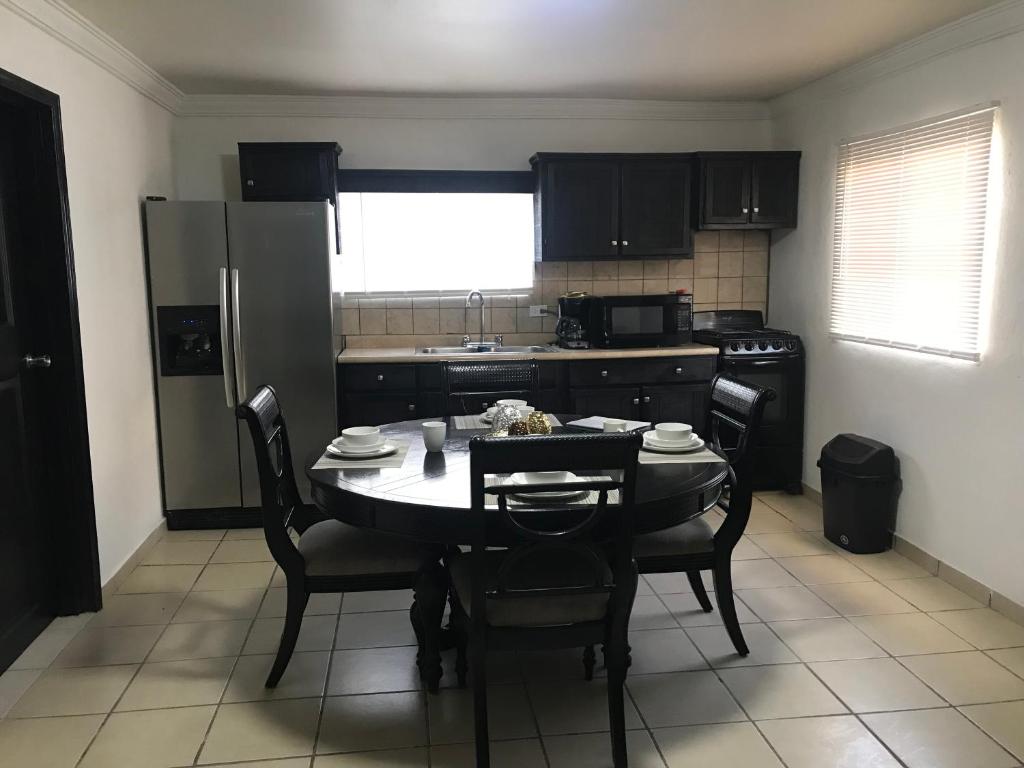 a kitchen with a table and chairs and a table and a kitchen with a kitchen at Apartamento Siesta Del Sol II in Puerto Peñasco