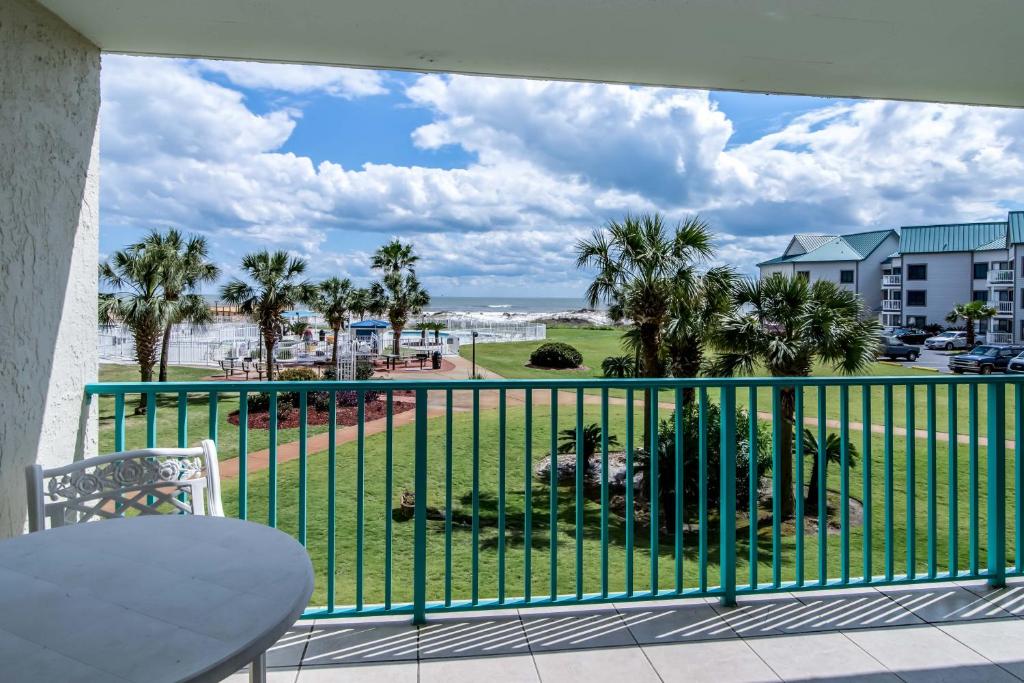 a balcony with a view of the beach and palm trees at Plantation Palms III in Gulf Shores