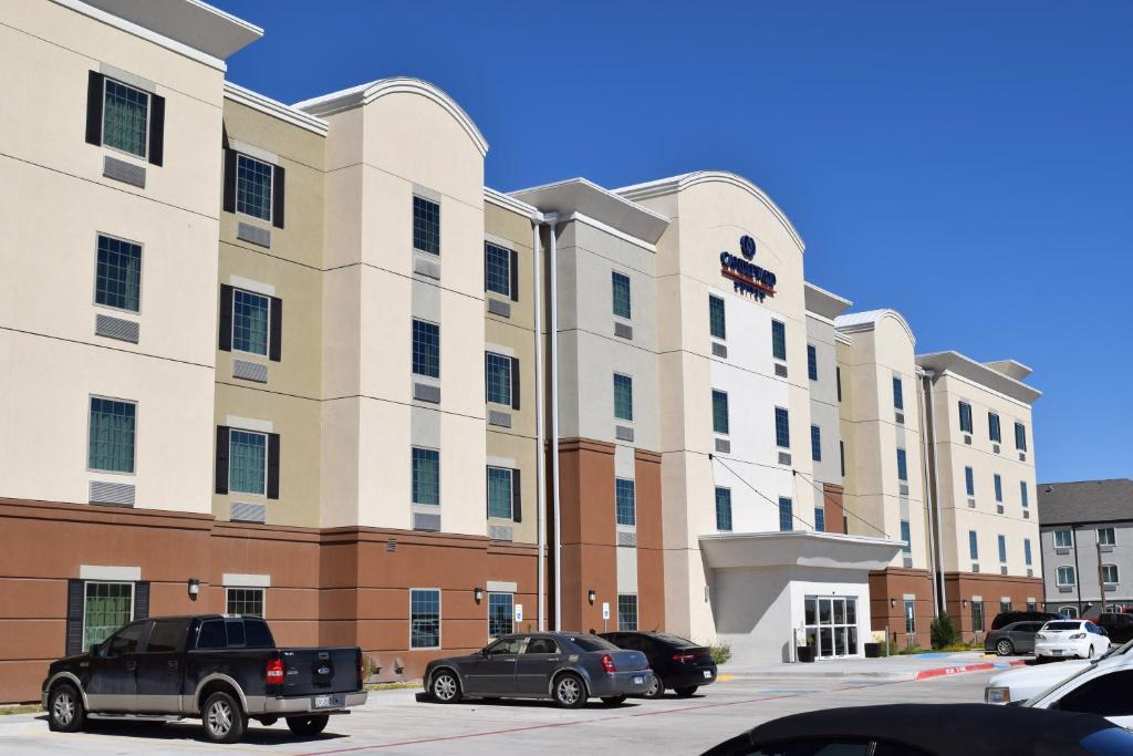 莫纳汉斯Candlewood Suites Monahans by IHG的一座大楼，停车场里停满了汽车