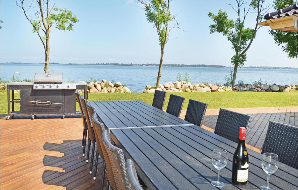 una mesa de picnic con copas de vino y una parrilla en 5 Bedroom Nice Home In Torrig L, en Kragenæs