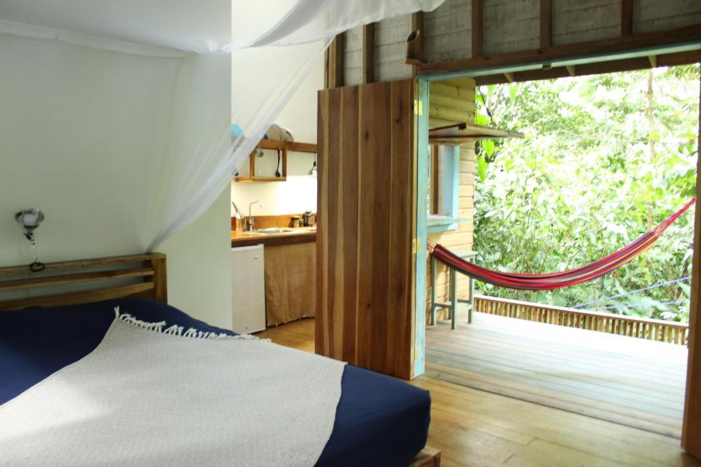 a bedroom with a bed and a large window at Jungle Paunch in Bocas Town