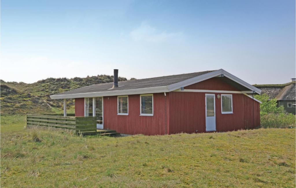 une maison rouge sur une colline avec un champ dans l'établissement 4 Bedroom Gorgeous Home In Fan, à Sønderho