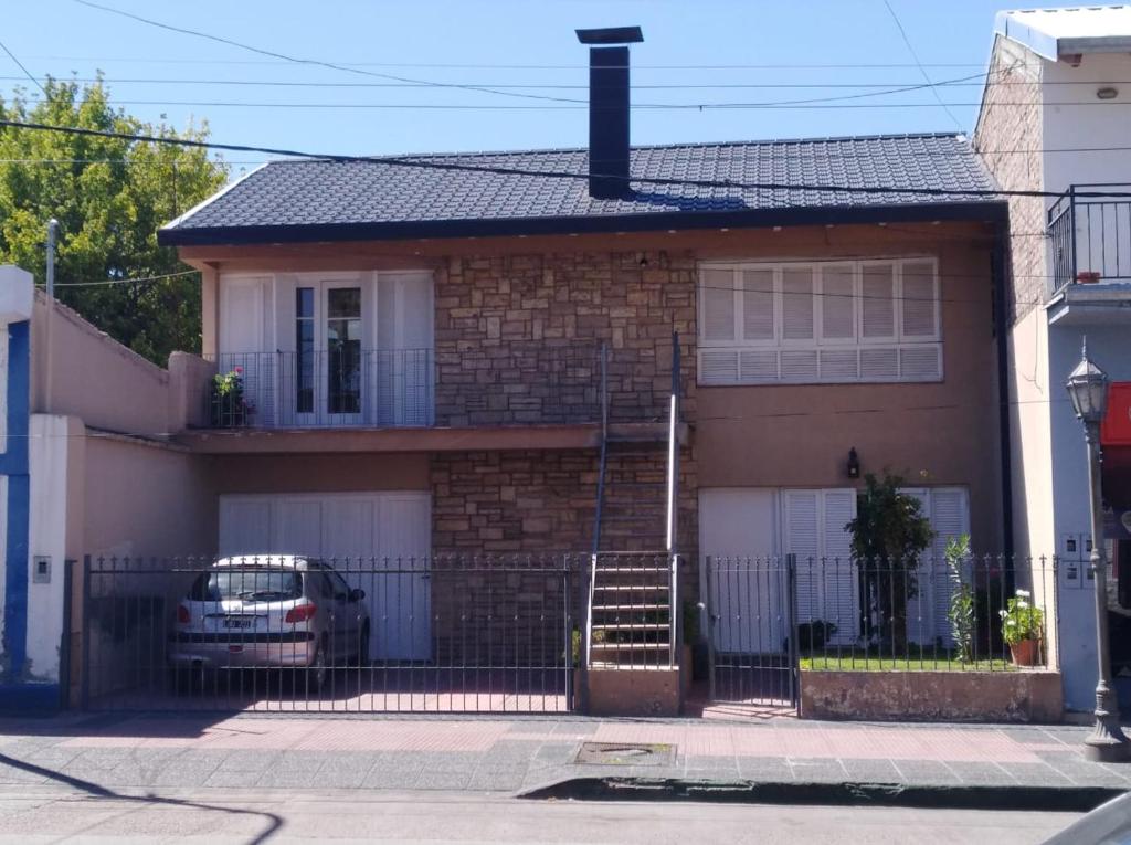 a house with a fence and a car in front of it at Departamento céntrico Tupungato in Tupungato