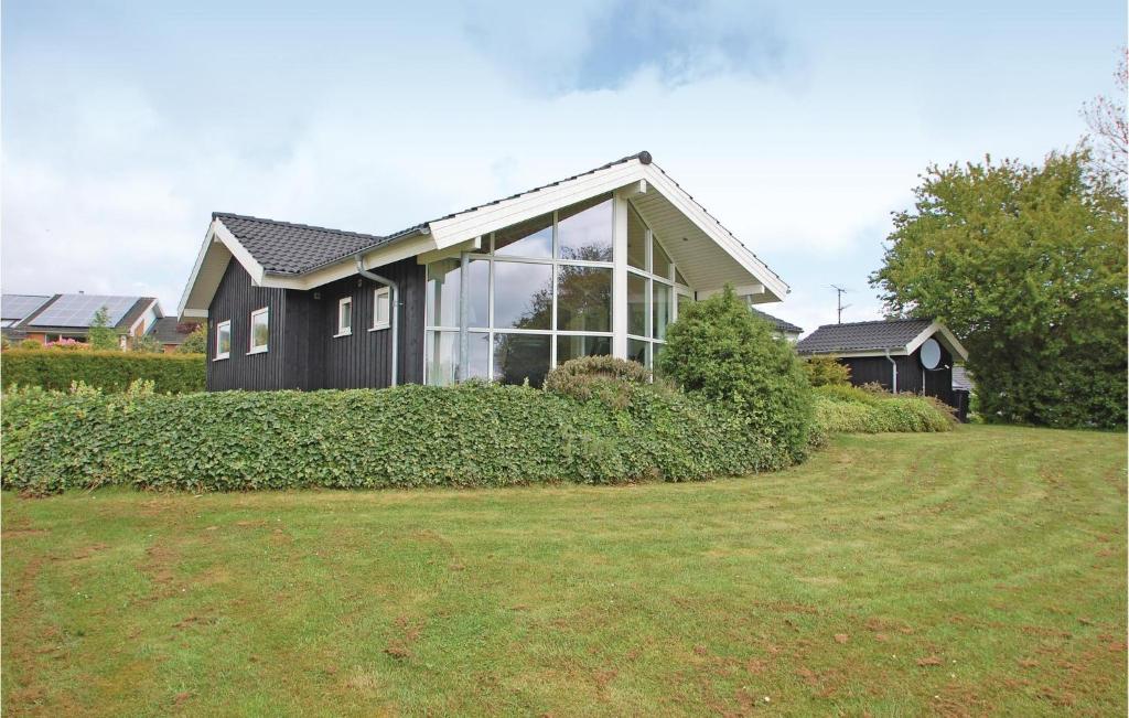 una casa con una gran ventana en la parte superior de un patio en Lovely Home In Haderslev With Kitchen, en Kelstrup Strand