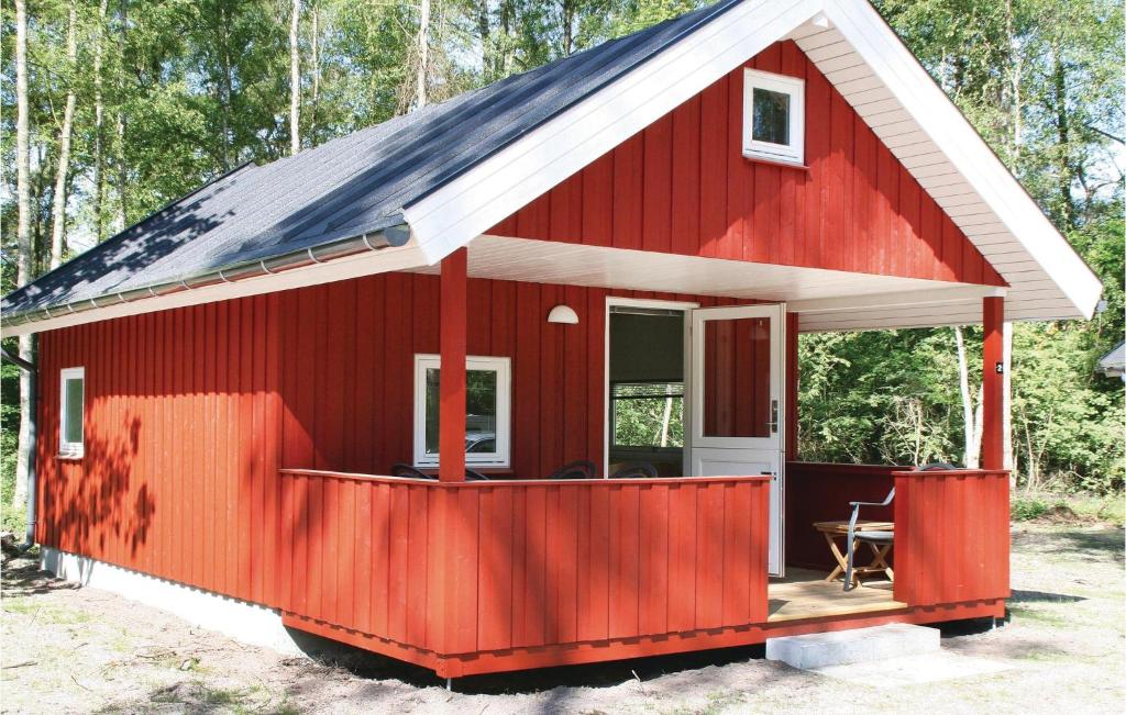 una casita roja con techo de gambrel en Juelsminde Campinghytte, en Juelsminde