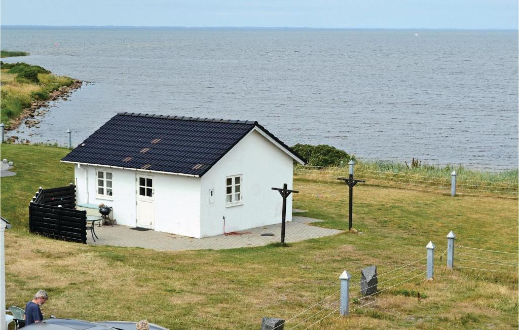 HemmetにあるStrandhyttenの水辺の黒屋根の小さな白い家