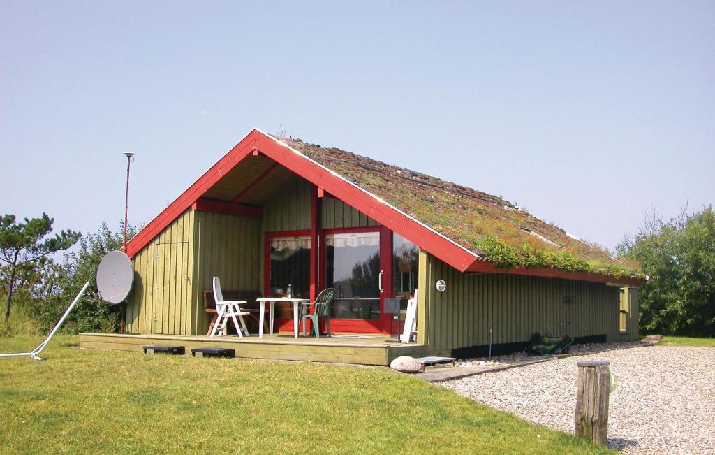 a small house with a grass roof with a table at 2 Bedroom Lovely Home In Rm in Bolilmark