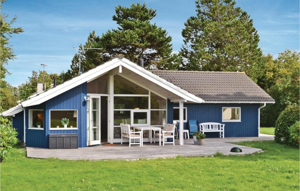 een blauw huisje met een terras en een tafel bij Lovely Home In Grsted With Wifi in Udsholt Sand