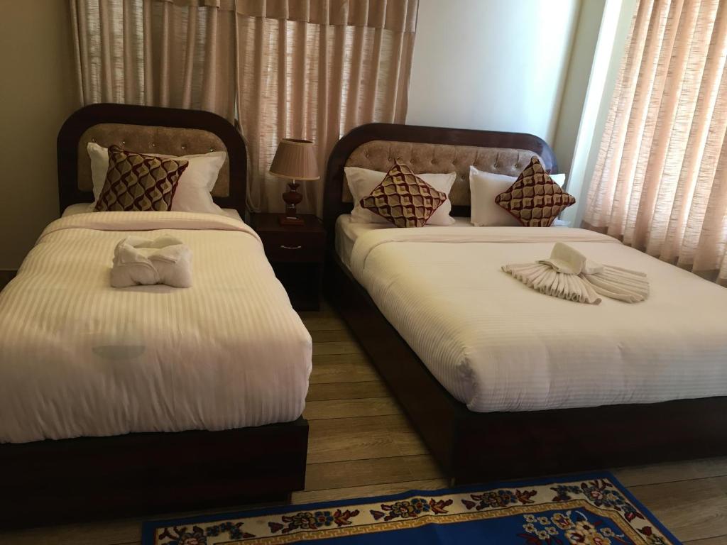 two beds in a hotel room with towels on them at Hotel Lilyland Pvt Ltd in Pokhara