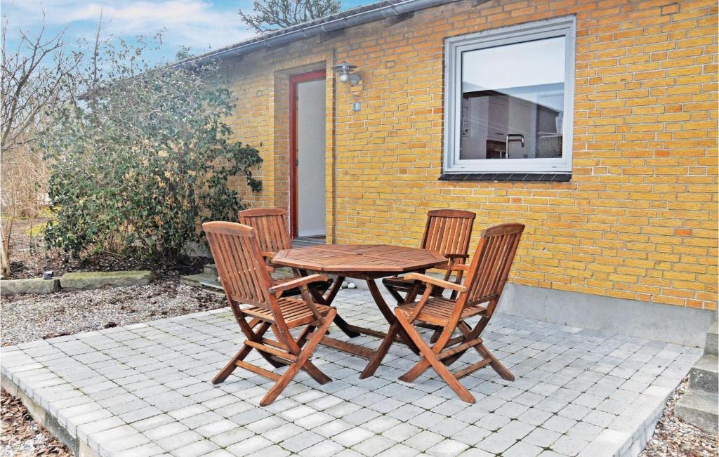 una mesa de madera y 4 sillas en un patio en Lovely Home In Sydals With Wifi en Skovby