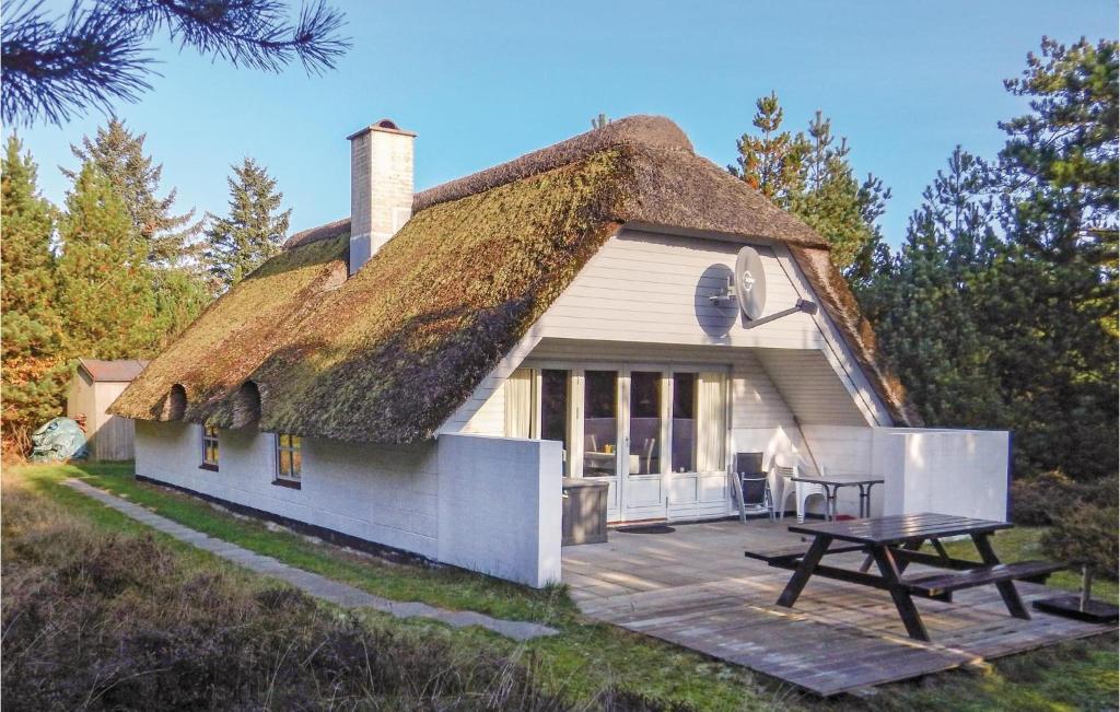 a house with a thatched roof with a picnic table at Awesome Home In Rm With Kitchen in Bolilmark