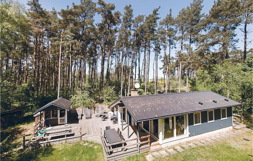 a blue house with a porch and chairs in front of trees at Holiday Home Munkegårdsskoven Nexø Ix in Spidsegård