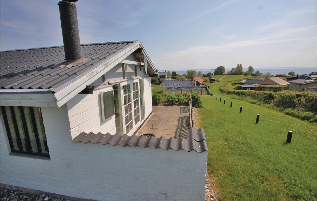 une maison blanche avec une terrasse couverte et un champ verdoyant dans l'établissement 2 Bedroom Lovely Home In Hejls, à Hejls